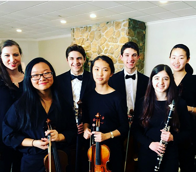 Post-concert smiles abound for Ladue All-State Orchestra members. Senior Grace Crockett, sophomore Anna Zhong, freshman Daniel Diringer, freshman Becky Lang, sophomore Jacob Sheldon, senior Evyn Levy and sophomore Shirley Pan pose Jan. 27. Not pictured is freshman and clarinetist Pema Childs, who played in the All-State Band. "A funny part about All-State was that we got out of rehearsal an hour early once to see a sunset, but it was cloudy, so there was no sunset to see," Sheldon said.