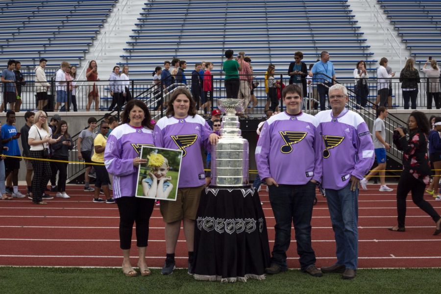 The Dougan family poses with the Stanley Cup on Ladue High School's football field Oct. 3. The Stanley Cup was brought to Ladue as a surprise for the Dougans to honor their sister, Ari Dougan, who passed away nearly two years ago. 