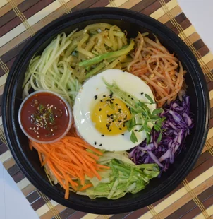 Shaking Bowl's one-of-a-kind veggie bowl. This dish is made up of mung bean sprout, carrots, red cabbage, zucchini, cucumber and a sunny side up egg. For a vegan alternative, the egg can be substituted for tofu.