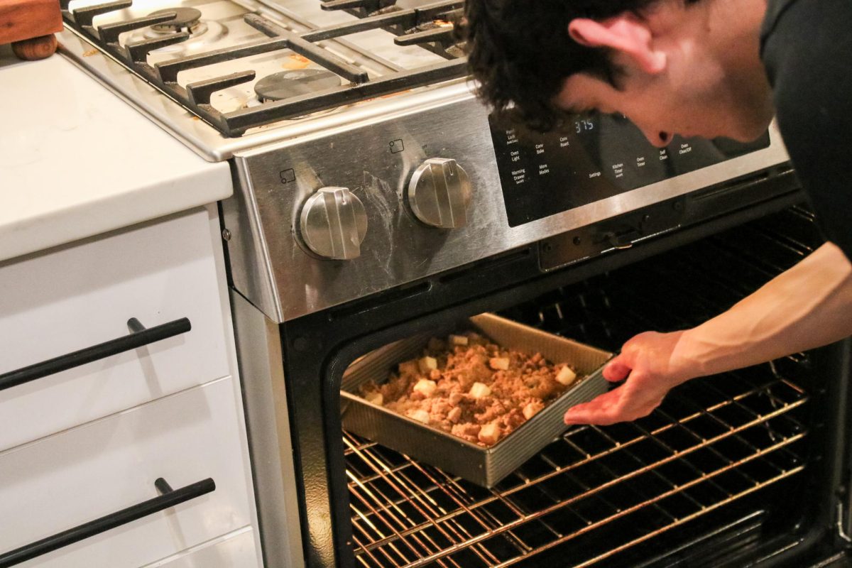 Tarek Al Husseini puts his bake-off apple crisp into the oven. He was attempting to recreate Mac's version without the directions. "The original crisp was flakey on the bottom, so I approached it like I would a pie crust," Al Husseini said.