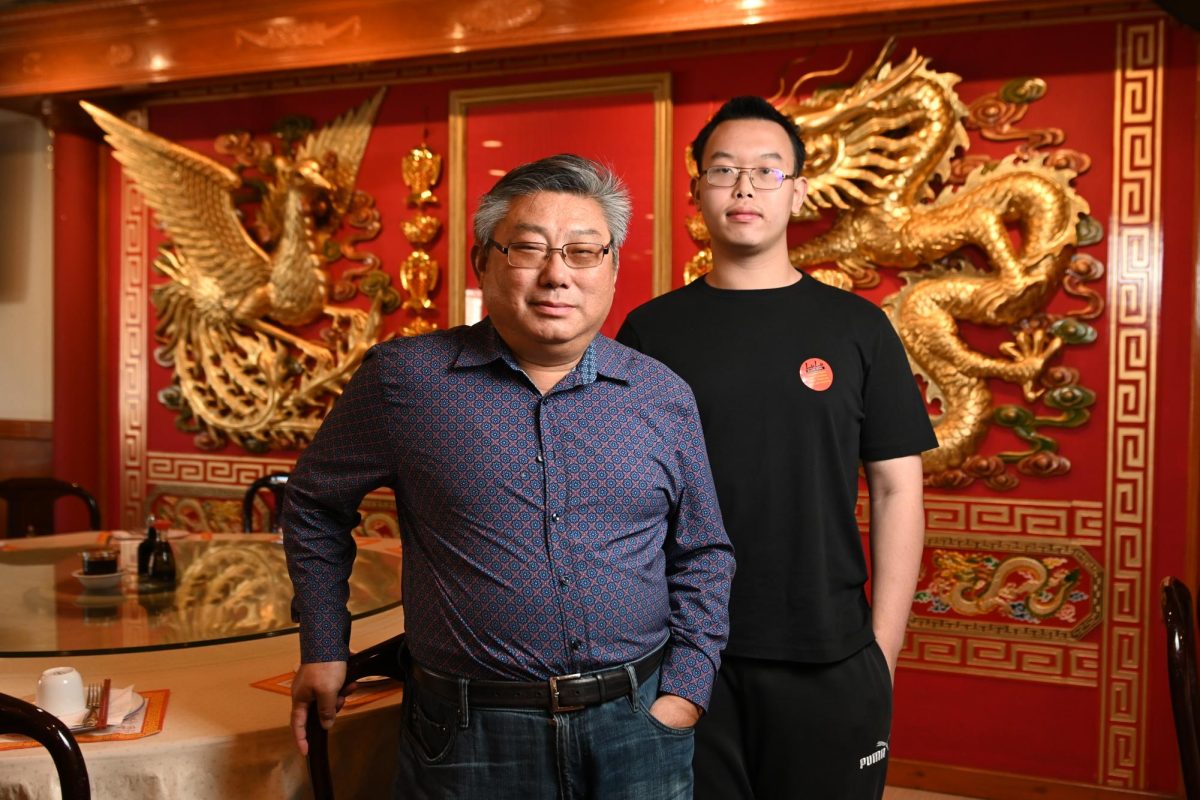 Co-owner Jerry Li stands next to his nephew Edison Lu in their family-owned restaurant LuLu's Seafood and Dim Sum Oct. 5.  The two spent nearly every day together greeting customers, serving their famous Cantonese food, and maintaining the restaurant. "The restaurant is a family business. The whole family is working together and contributing their skills to keep the restaurant alive," Lu said. 