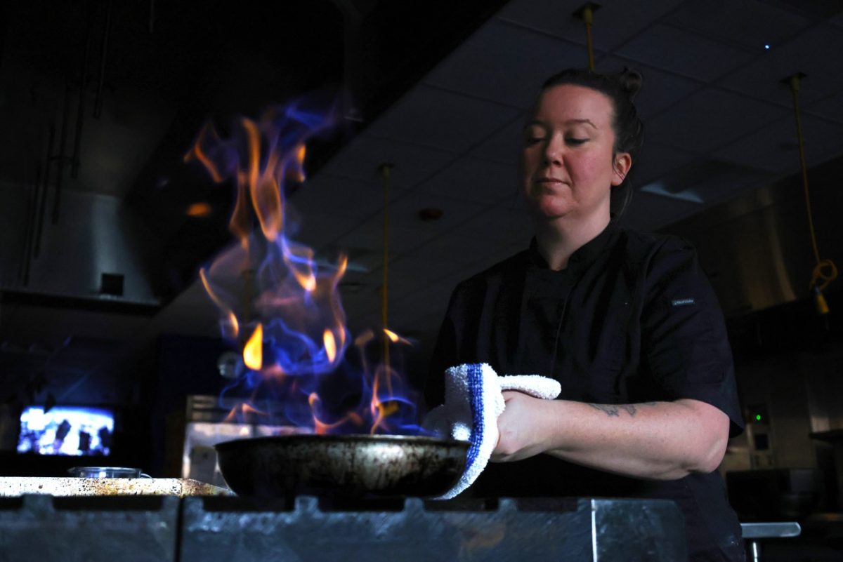 April Dalton cooks Bananas Foster, a dessert consisting of bananas sautéd in butter, sugar and cinnamon. The bananas were cooked over a fire with rum and served atop a scoop of vanilla ice cream. “[Cooking] is not just like reading a piece of paper and making it happen," Dalton said. "There's a lot more involved and I don't think people realize that when they get into the kitchens."