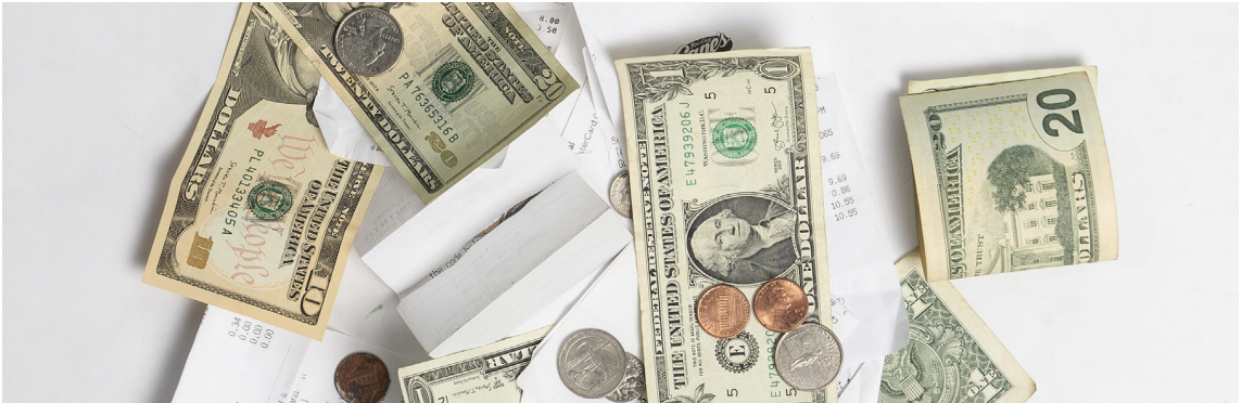 A pile of bills, coins and reciepts.