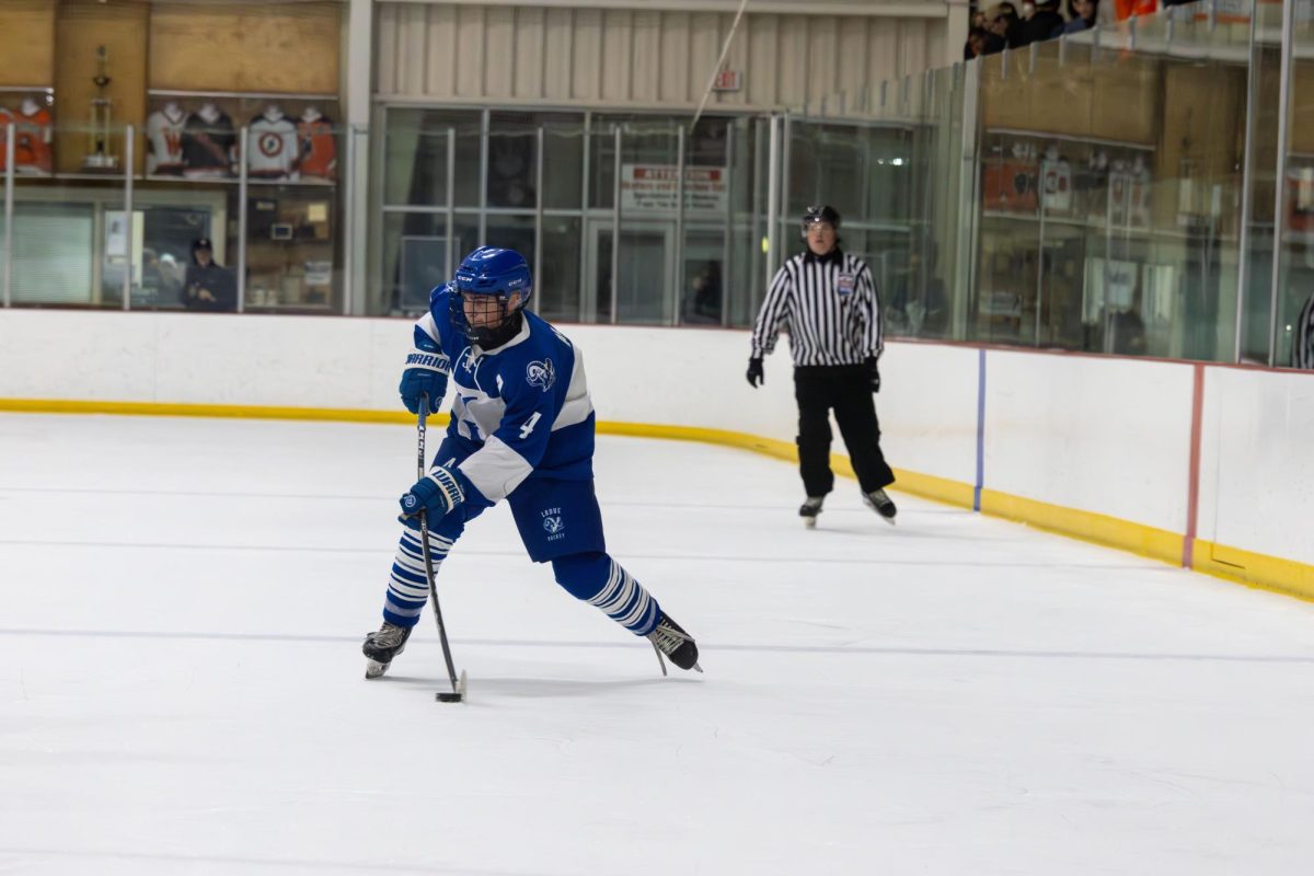 Anticipating the play, Hobey Alton (12) gears up to make a pass to his teammate. Ladue Boys Hockey played this game against Webster Groves last winter. "This year, everyone's focused on winning and that's it," Alton said.