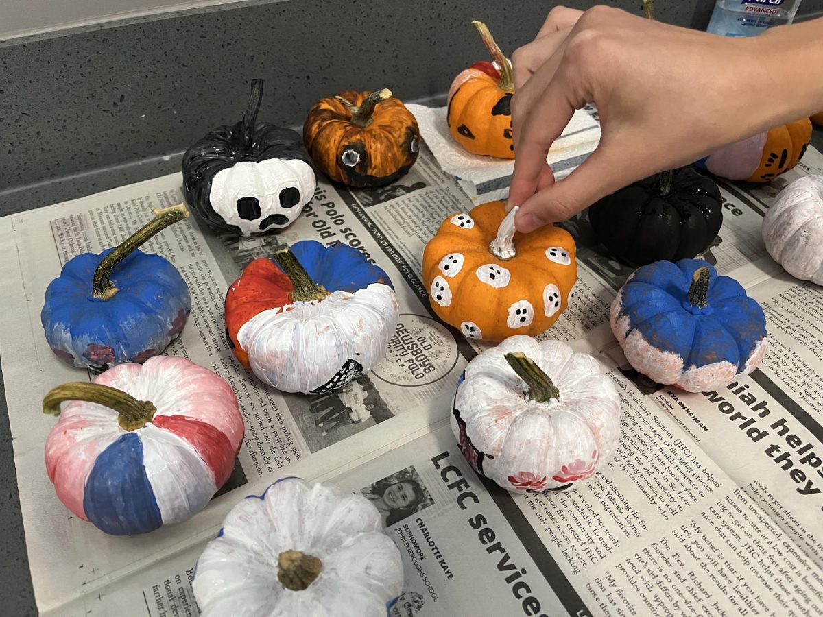 Luca Klyachko (11) picks up the winner of the pumpkin painting competition. The pumpkin was painted by Maya Varadachari (12). “It’s a fun social event to come in and see other people who also enjoy French culture,” Klyachko said. “In addition to a lot of snacks, [it] makes for a pretty good time.”