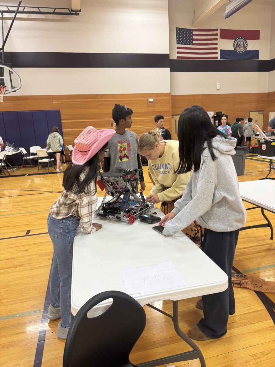 Team Tricerabots collaborates in fixing  their robot. They competed at Troy Buchanan High School Oct. 18. “We made a lot of new friends,” Antara Sriram (10) said. “Which is a great part of the competition.”