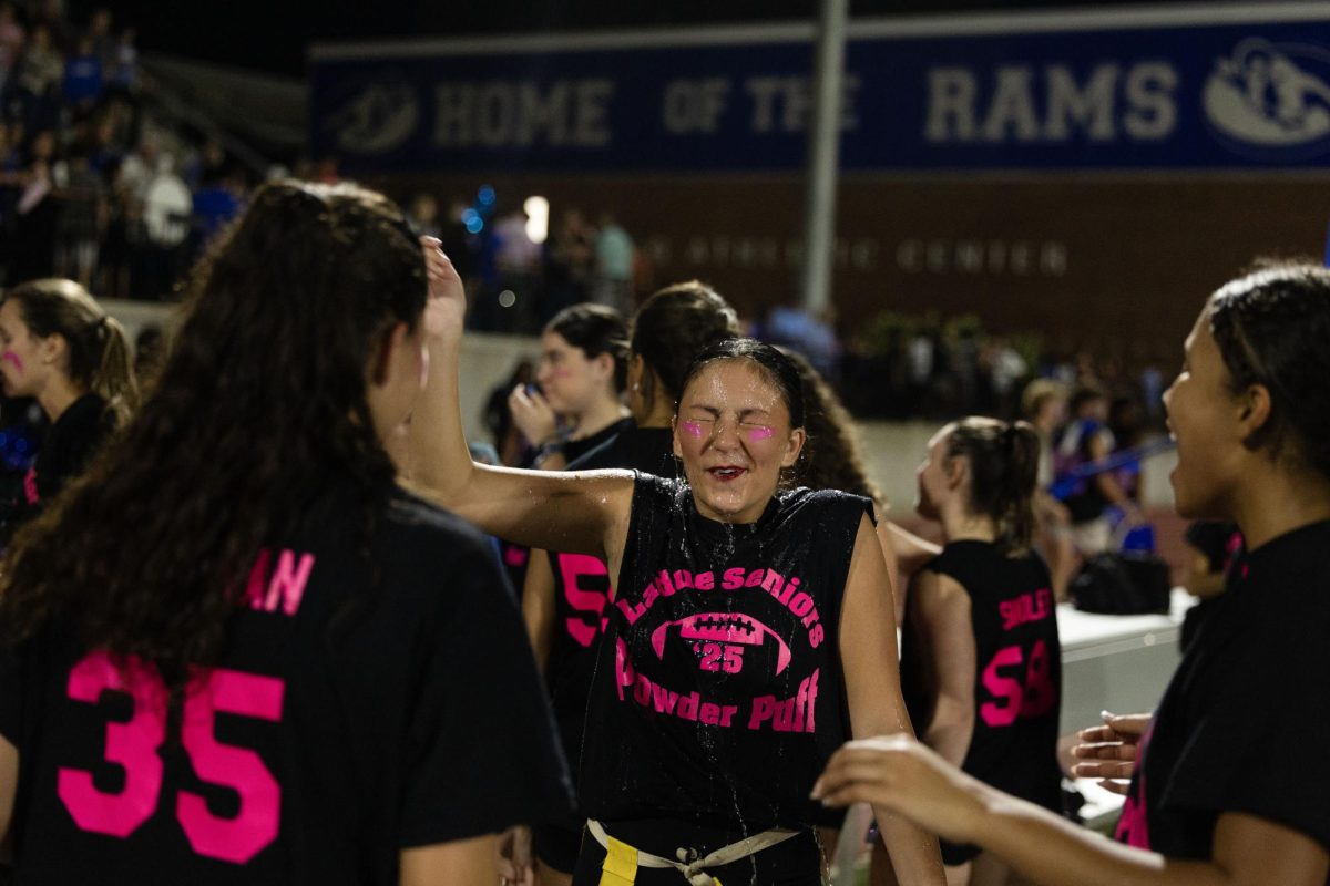 Juniors and seniors compete at the annual Powderpuff football game Sept. 29. Campbell Cross (12) cheered on the sidelines with the boys cheer team, The Squad. “Powderpuff was really fun this year, especially getting to cheer on the sidelines with the boys and rushing the field after the senior win,” Cross said.