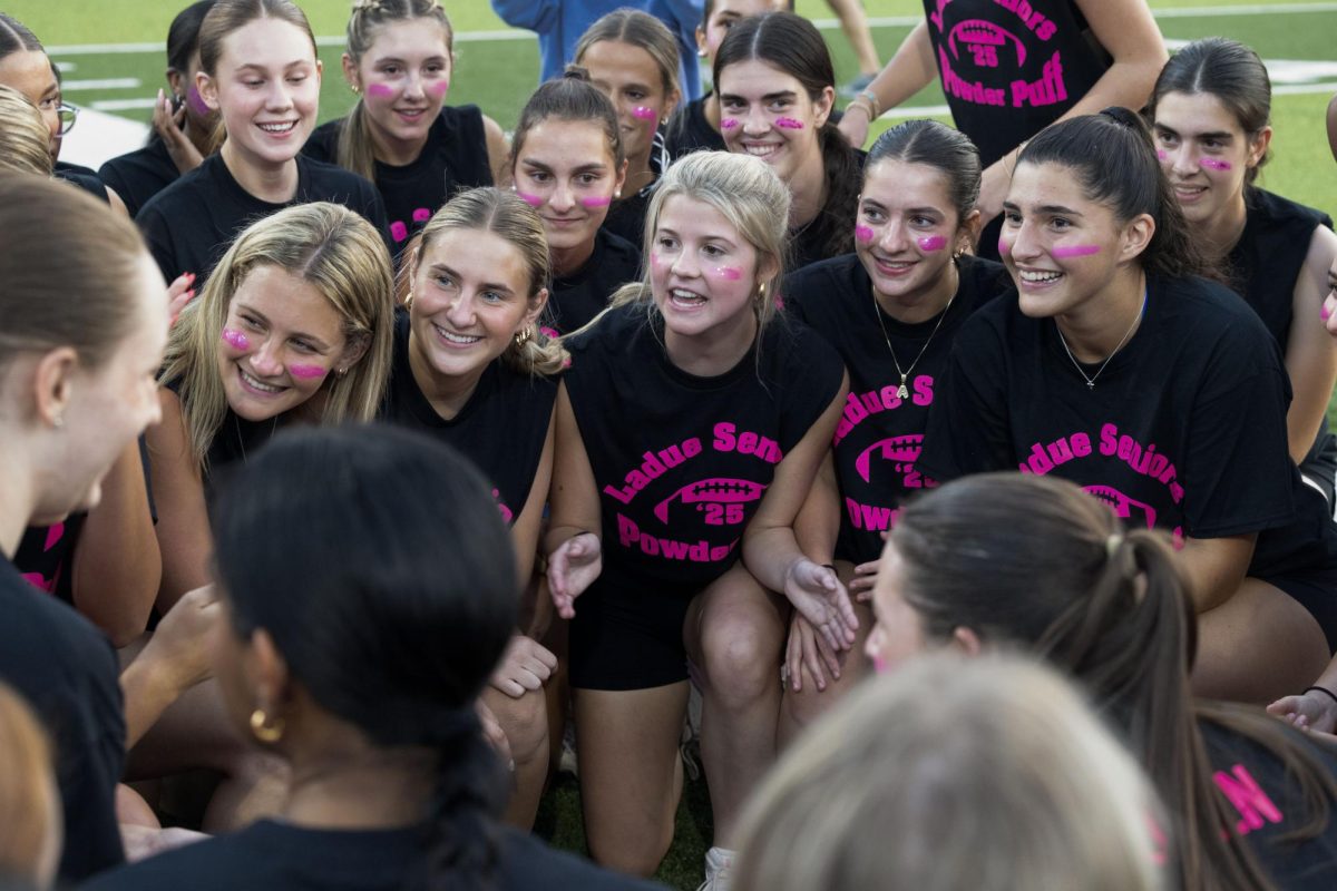 Juniors and seniors compete at the annual Powderpuff football game Sept. 29. Campbell Cross (12) cheered on the sidelines with the boys cheer team, The Squad. “Powderpuff was really fun this year, especially getting to cheer on the sidelines with the boys and rushing the field after the senior win,” Cross said.