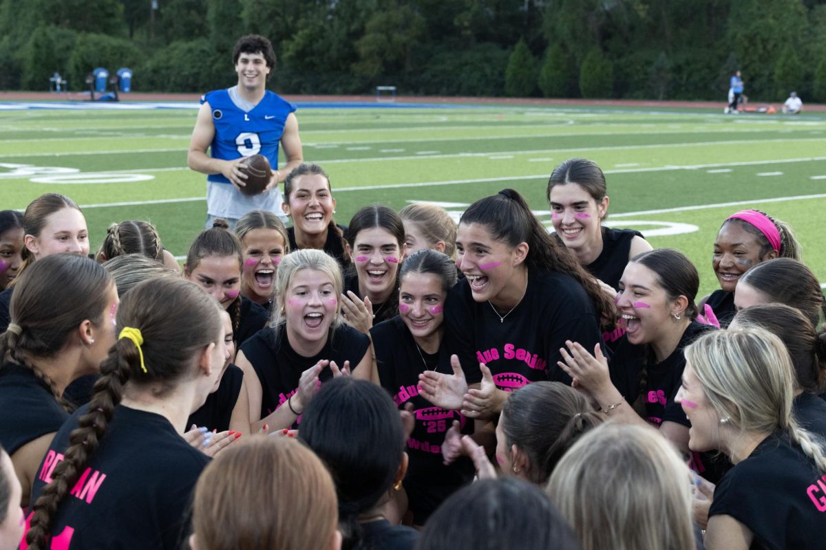 Juniors and seniors compete at the annual Powderpuff football game Sept. 29. Campbell Cross (12) cheered on the sidelines with the boys cheer team, The Squad. “Powderpuff was really fun this year, especially getting to cheer on the sidelines with the boys and rushing the field after the senior win,” Cross said.