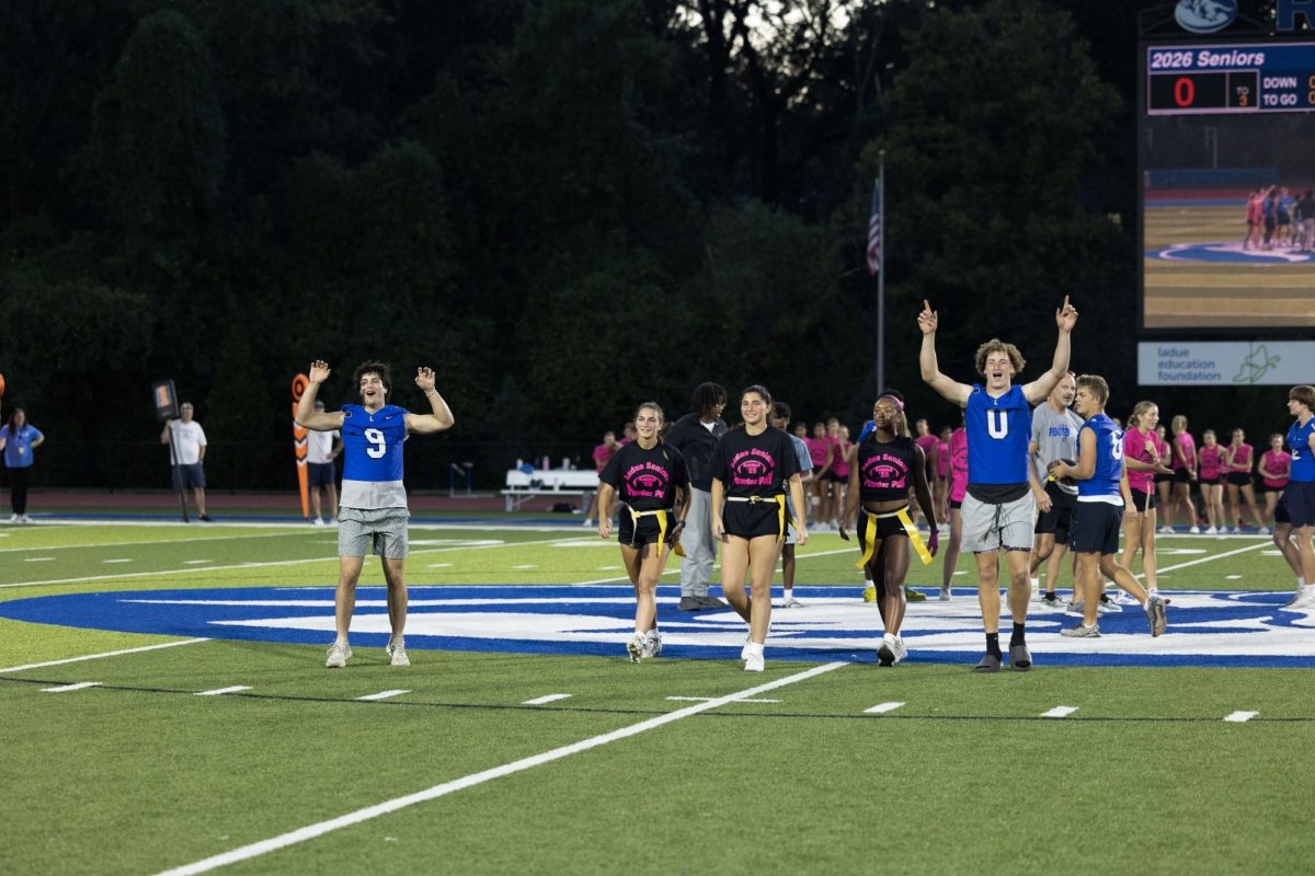 Juniors and seniors compete at the annual Powderpuff football game Sept. 29. Campbell Cross (12) cheered on the sidelines with the boys cheer team, The Squad. “Powderpuff was really fun this year, especially getting to cheer on the sidelines with the boys and rushing the field after the senior win,” Cross said.