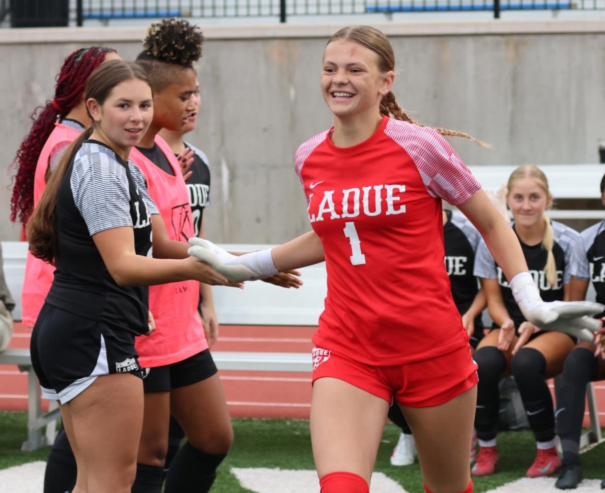 Avery Warwick (11) high-fives teammates before their game against Lafayette High School. The team won 1-0 in overtime. “The most important quality is composure,” Warwick said.
