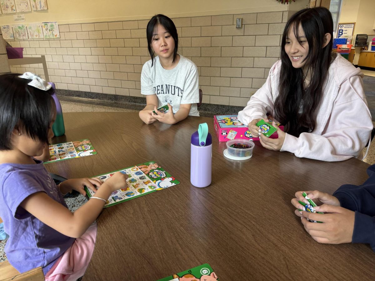 Kimmi Lin (12) and Lily Zhou (9) play vocabulary bingo with three Conway students. This is the second time they have worked with the Conway ESOL Program. “[By being in English Club] I hope to make more connections with kids and help them,” Zhou said.
