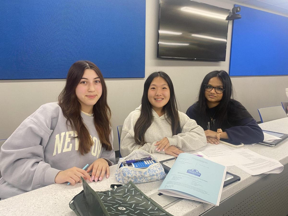 Elle Saleeby (10), Renee Song (10) and Sasha Prasad (10) sit at the top row of the teleconference room among notes and informational packets. They grouped together to rehearse their case after Miller’s lecture. “The witnesses rehearse with their attorney, so they know generally what they're going to say,” Hammerman said. 
