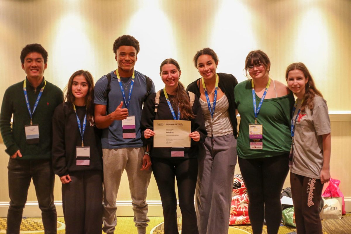 Seven members of the Rambler Yearbook staff stand with their fourth place certificate. 