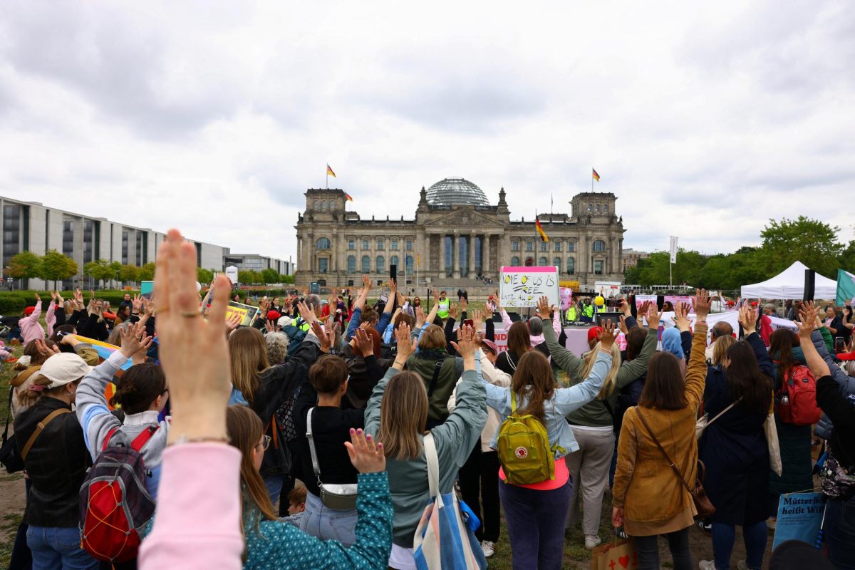 Women raise their hands at a demonstration in front of the Reichstag, the German parliament building, as part of a campaign advocating for equal rights for mothers, in Berlin, Germany May 10, 2025. REUTERS/Nadja Wohlleben