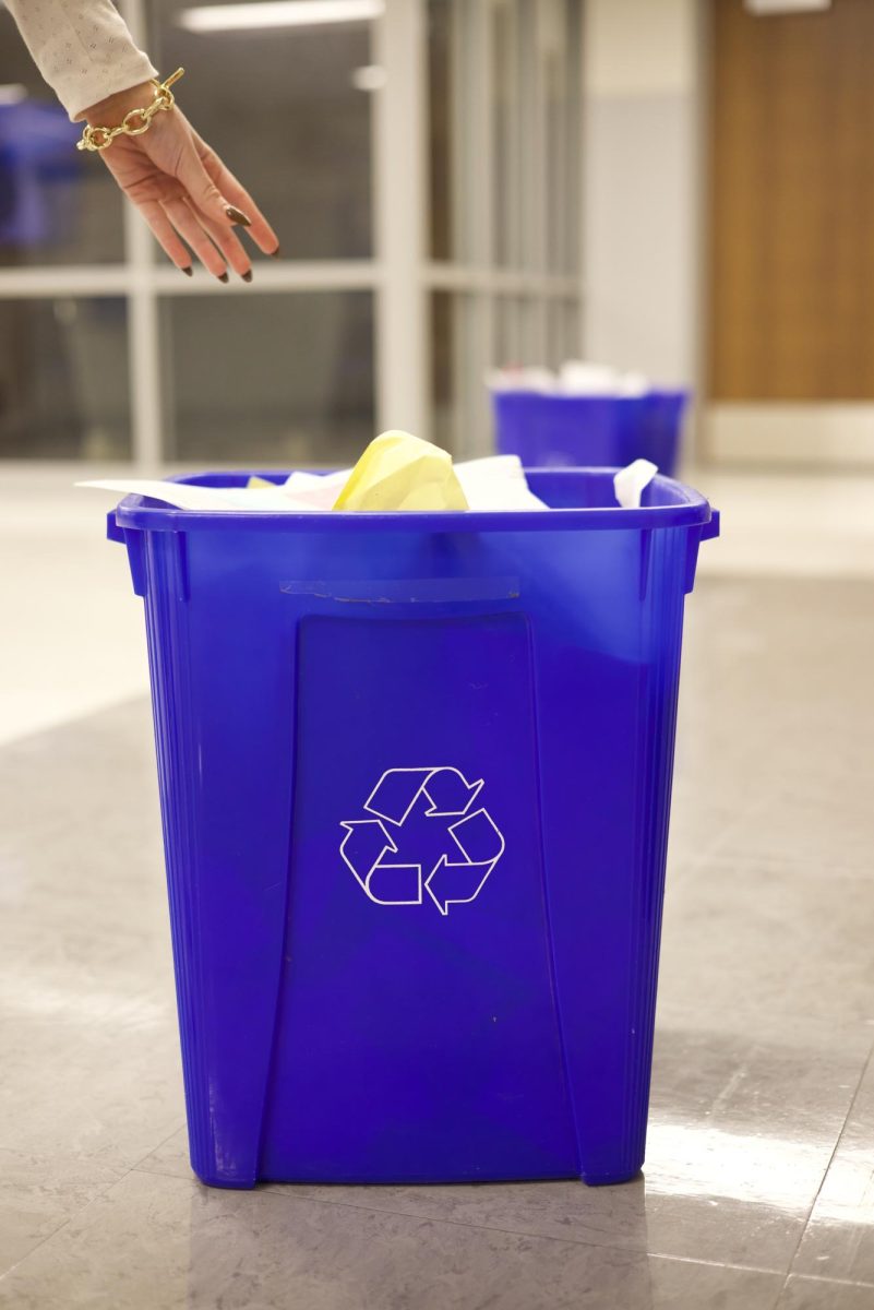 A student reaches into a recycling bin to remove trash. The members of Elements sort the recycling every Thursday to separate trash from recycling. "[The members] go get big bins from outside and then go around to each classroom and collect the recycling," English teacher and club sponsor Abby Eisenberg said. "The hard part is they also try to go through and sort out the trash or anything that's been contaminated."
