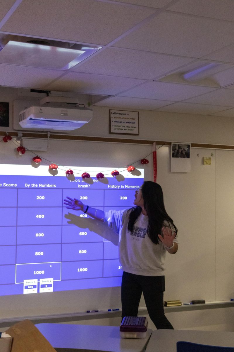 FEMCO club president Queena Xu (12) discusses the categories of Jeproady. The money raised from the game was donated to CHIC, an organization who makes reusable menstral products for women in Ethiopia. "I'm glad that we are working to make a difference while also educating about feminism," Xu said. 