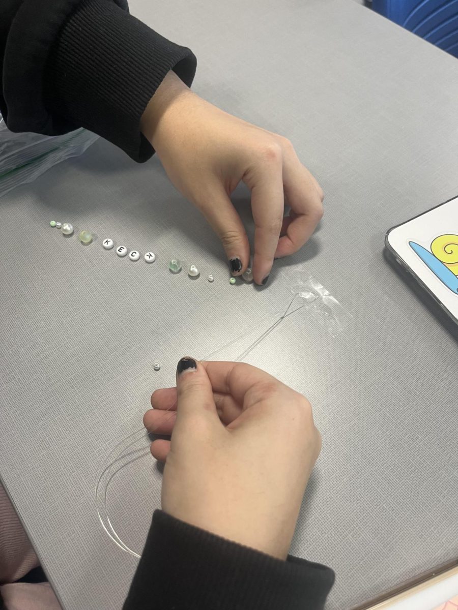 Camilla Chen (11) picks out which beads to use in her phone charm. During their meetings, Beading Club always provides a vast array of bead styles and colors for students to choose from. "I'm excited to finish my phone charm," Chen said.