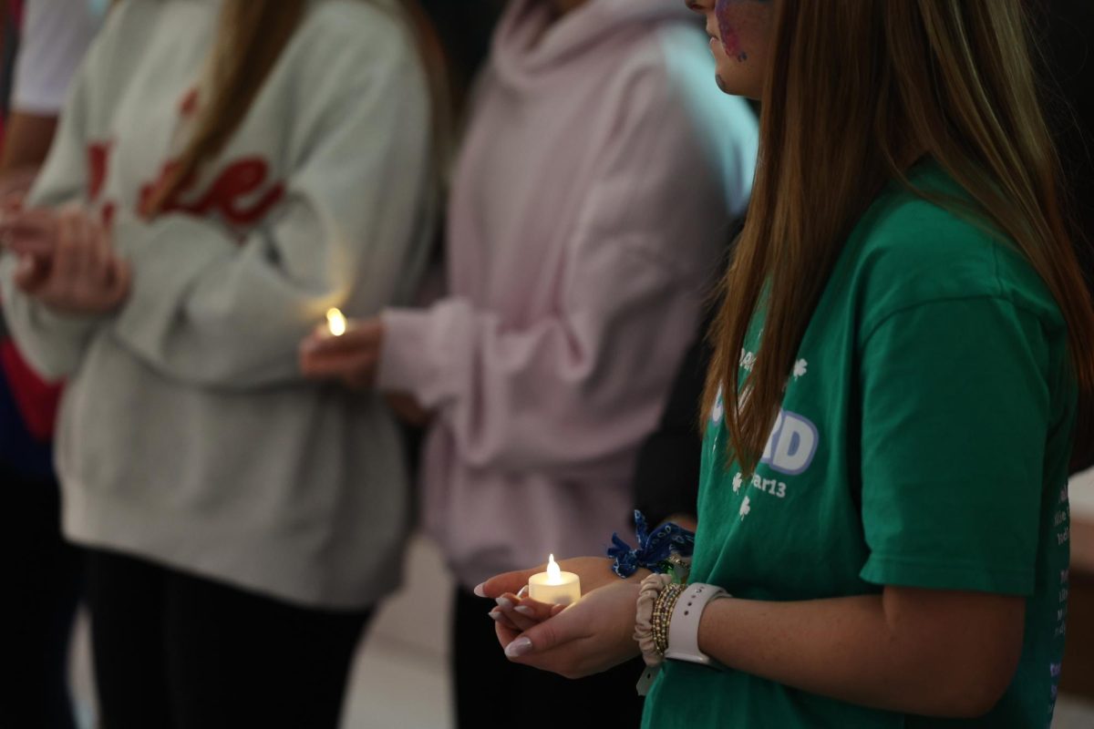 Morale Leader, Allie Glidewell (12), holds a candle in a circle with everyone at the event. The candle are used to shine a light on the children dance marathon supports but also those that are not able to receive donations or enough funding.