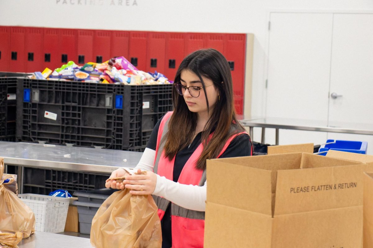 Sophia Anton (12) volunteers with NHS, packaging food at Operation Food Search Jan. 22. She obtained over 40 volunteer hours in the past year, which inspired her to apply for NHS president. “My role as president is to set expectations and cycles for the new year,” Sophia said. “One of my really big expectations and goals has been to introduce volunteer opportunities that are meaningful and help people in really urgent need.” 