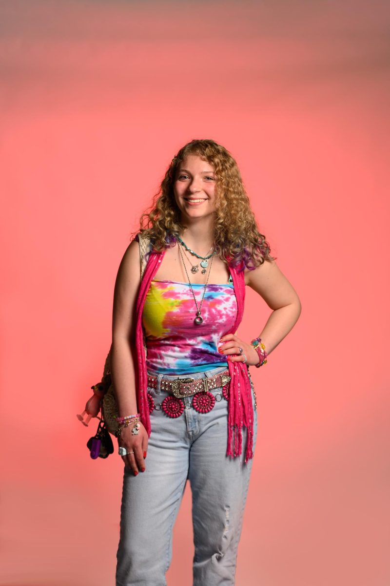 Kyra Siegel (11) poses in an outfit comprised entirely from thrifted clothes and handmade jewelry. Kyra has spent years building a collection of jewelry pieces. "All of my necklaces are handmade," Kyra said. "The silver chain is my mother's and she used to wear it every day. I put a lot of effort into making and designing the blue necklace, and it's one I'm very proud of."