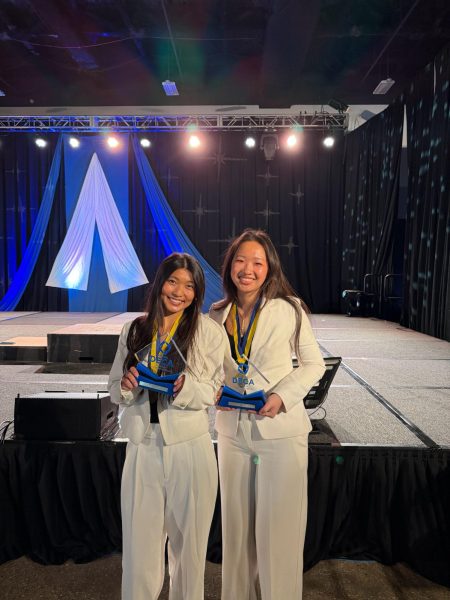 Zoe Mei (10), recipient of the Billy Michal Award, and her partner, Sydney Gao (10) pose with awards for their DECA project, EmpowerEd. The project developed into a central passion for Mei and something she would like to continue. "St. Louis is special in the way that there is always an opportunity to take a step further and deepen impact. I hope to expand the scale of EmpowerEd, and continue helping the families out at TAP.