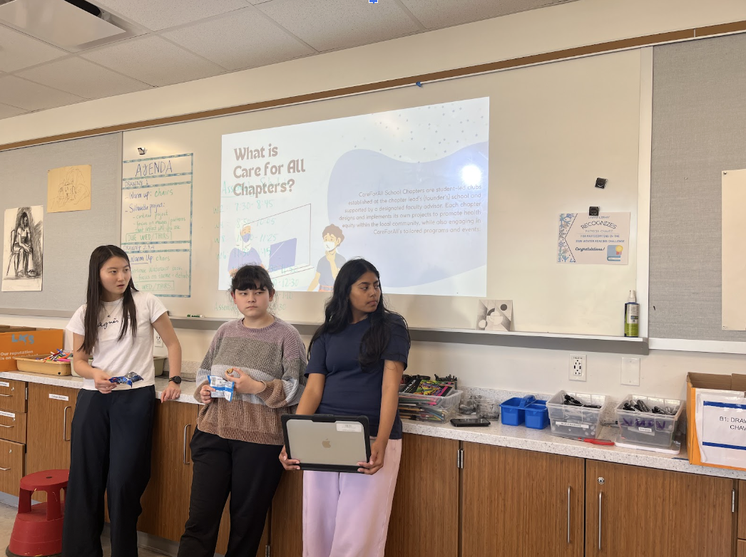  CareForAll Chapter Treasurer Hotaru Murashita (11), Secretary Emi Kodner (11) and Vice President Sarmistha Pulagram (11) stands by as Chapter President Oluwatomisin Falako (not pictured) presents a slide covering the purpose of the club. Chapter leaders are excited for the future of the club. "We're going to have student-led projects," Falako said.
