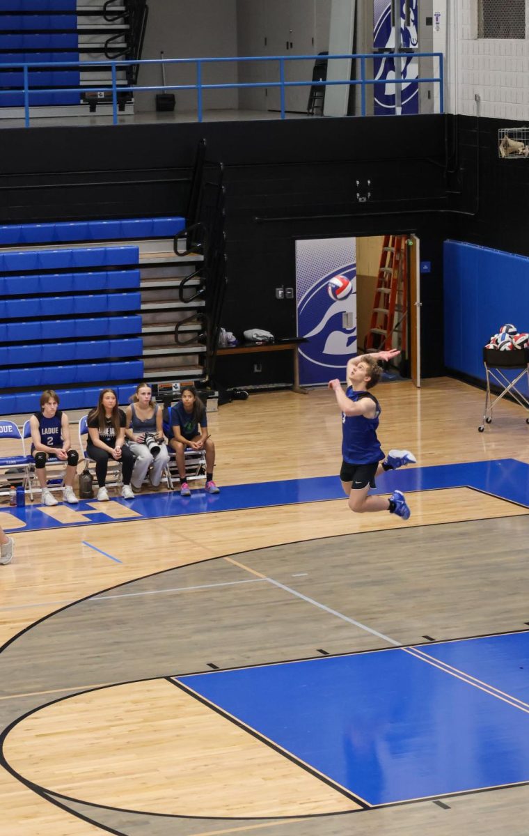 Tennyson Summer (12) jumps as he serves the ball against Eureka. The Rams swept the Wildcats to keep their eight win streak and remain undefeated on the season. "It was a really good feeling knowing we can win, even when we don't have all of our players," Summers said.
